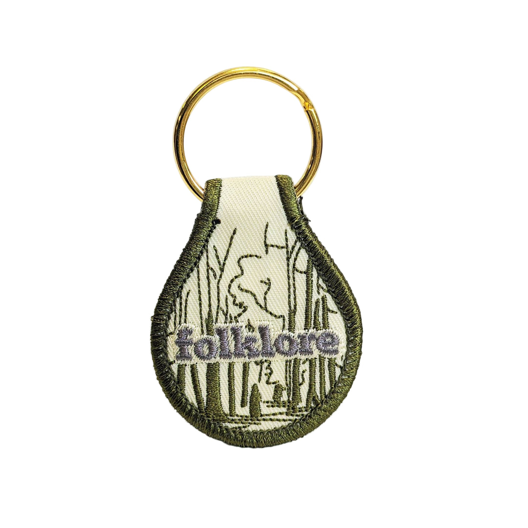Keychain with 'folklore' text and design on a white background