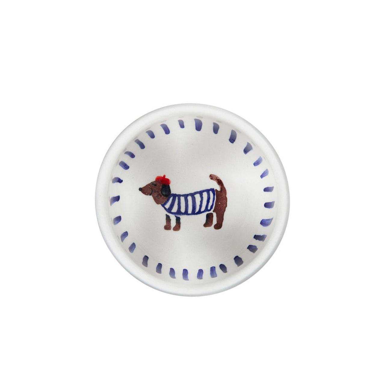 Small white plate with a dog illustration wearing a blue sweater on a white background