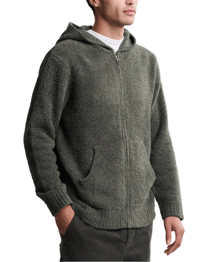 Man wearing a green fleece hoodie on a light gray background