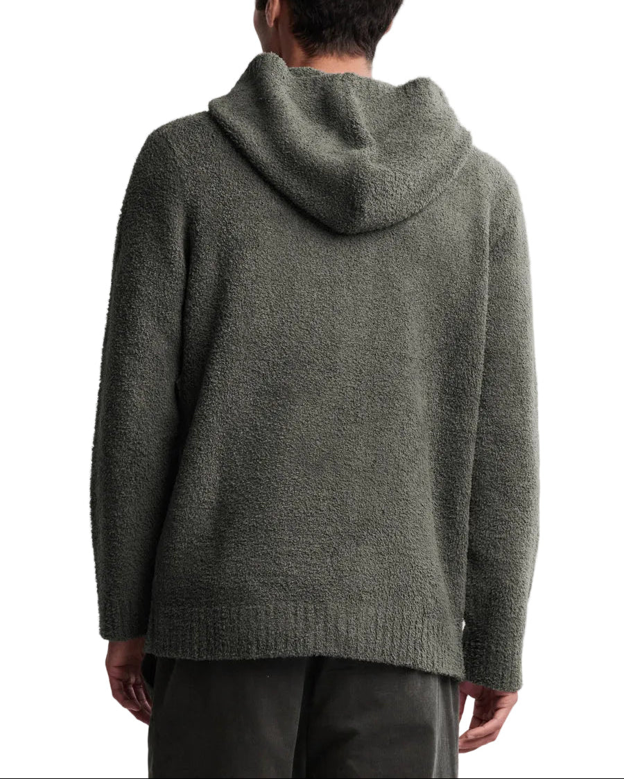 Person wearing a green hooded sweater from behind on a white background