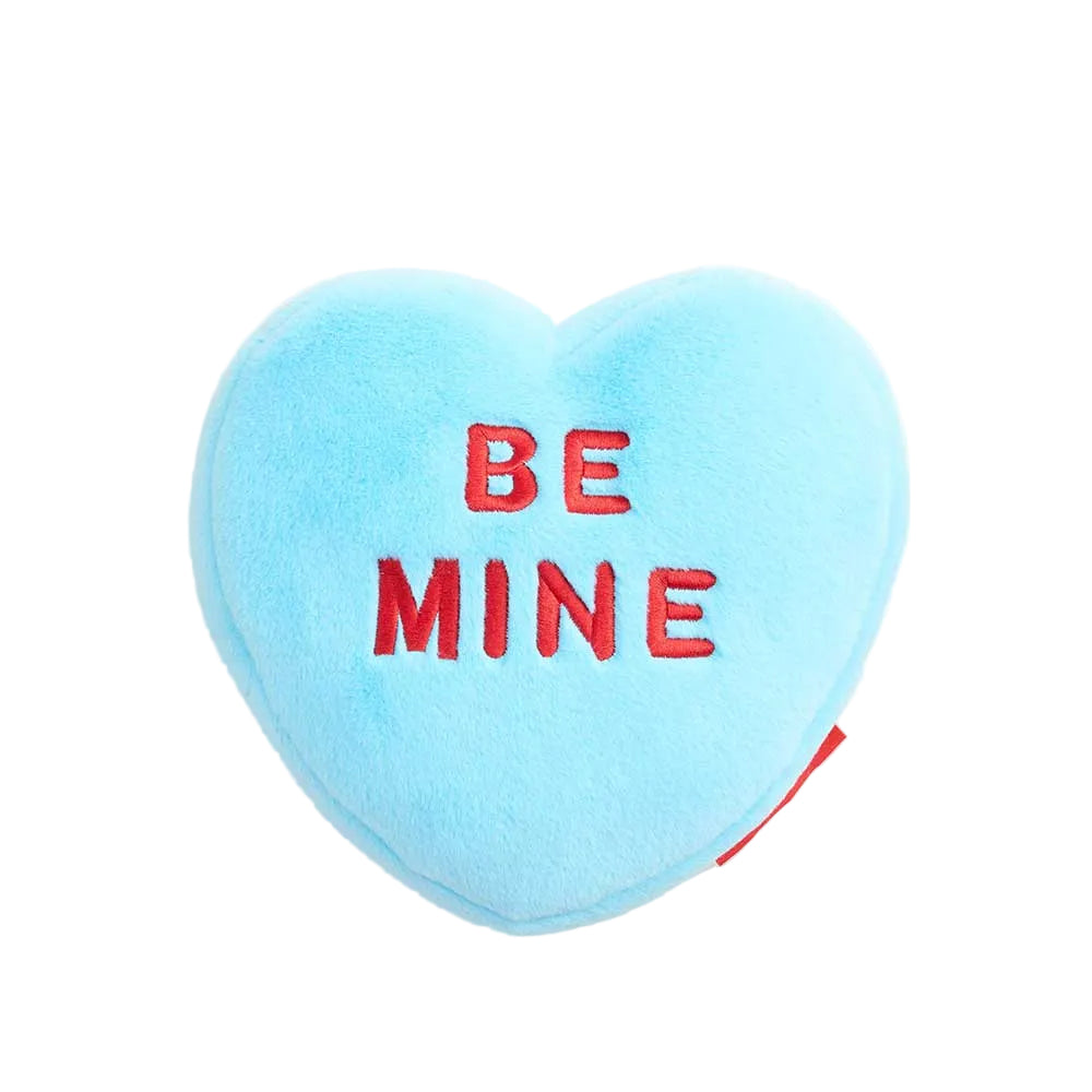 Heart-shaped blue pillow with 'BE MINE' text on a white background