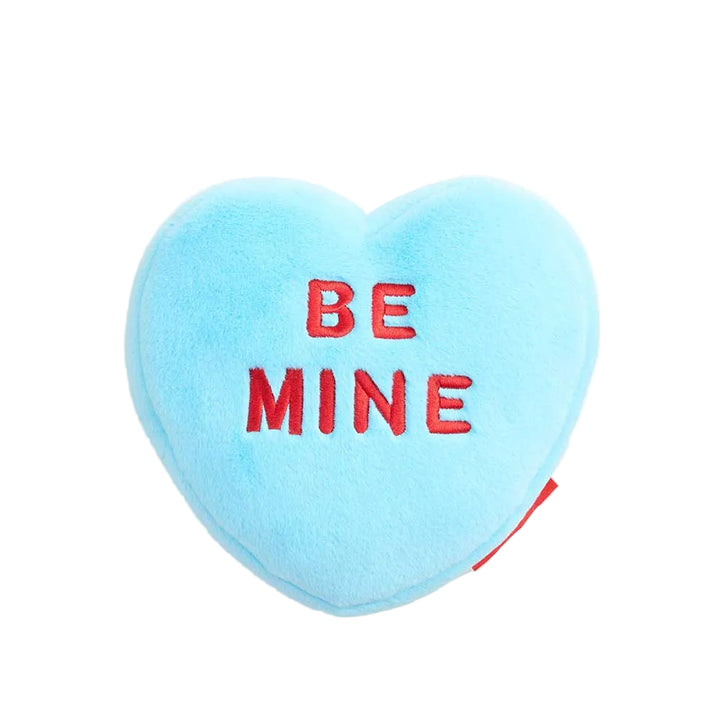 Heart-shaped blue pillow with 'BE MINE' text on a white background