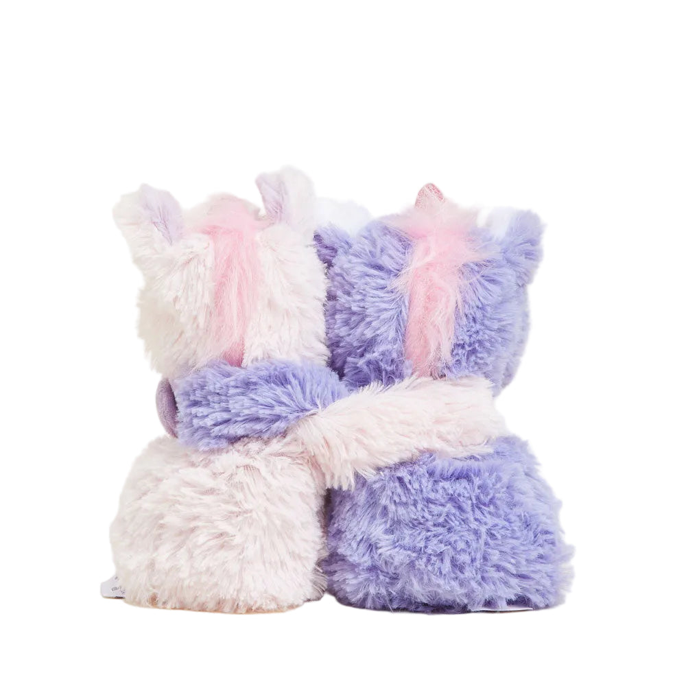Two fluffy, pastel-colored plush toys resembling unicorns on a light background