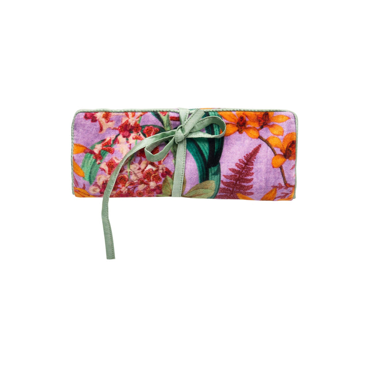 Floral-patterned jewelry roll with a green ribbon on a white background
